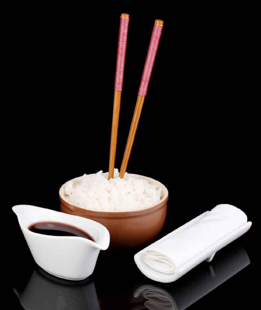 un bol de riz avec baguettes plantées dedans
