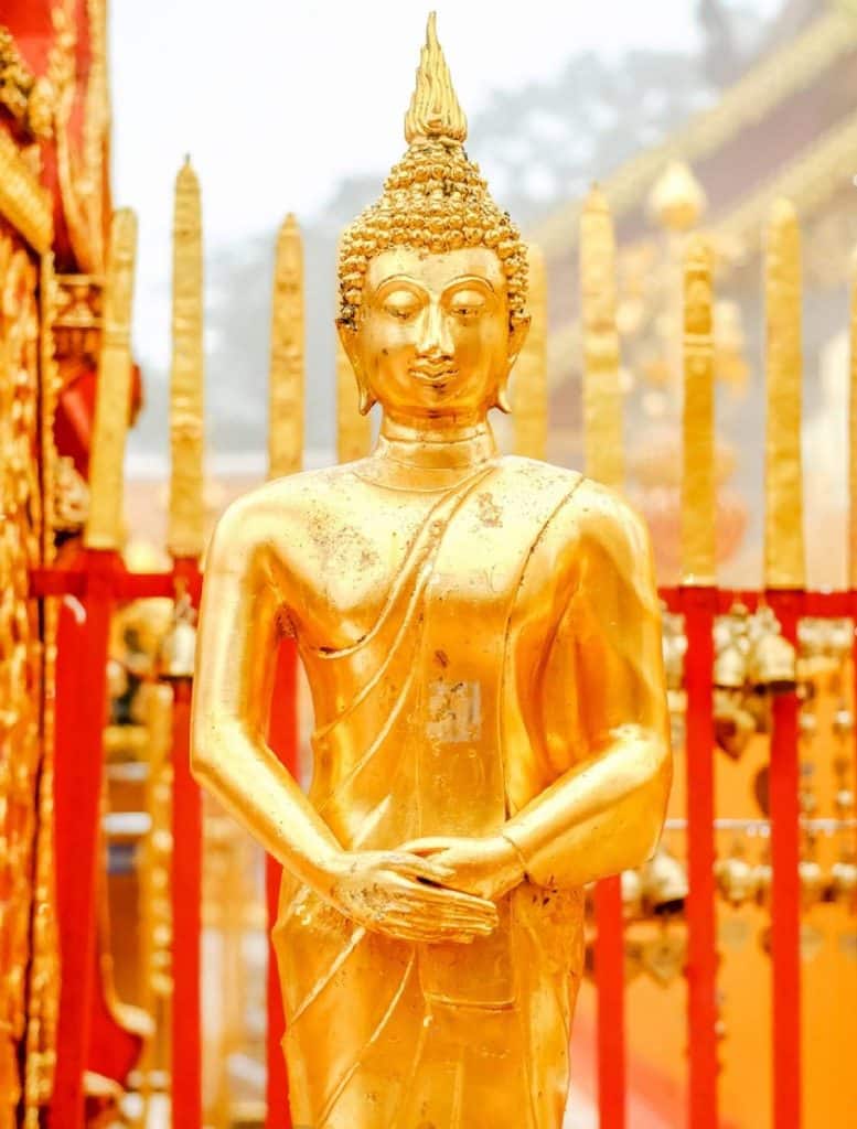 bouddha debout avec ses mains croisés devant lui immobile