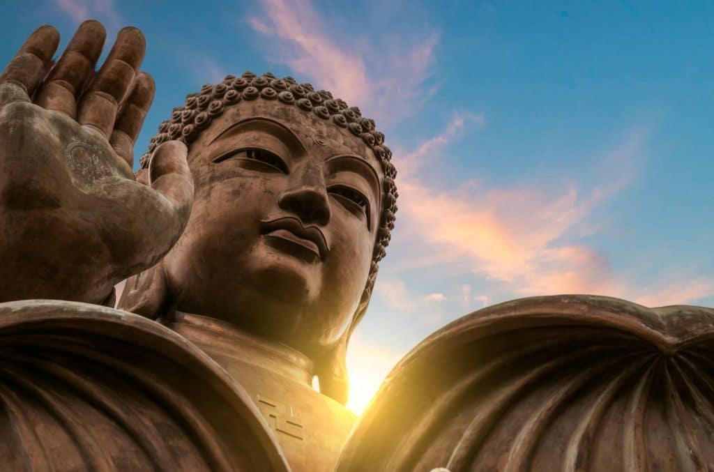 bouddha en pierre levant la main droite