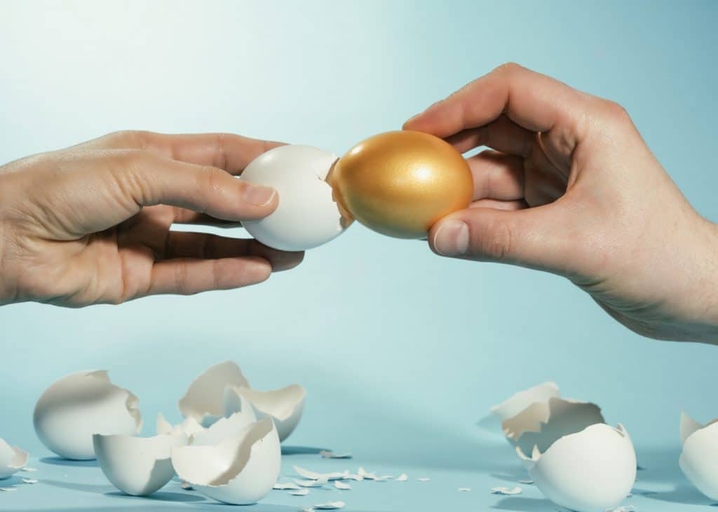 un oeuf doré dans une coquille blanche